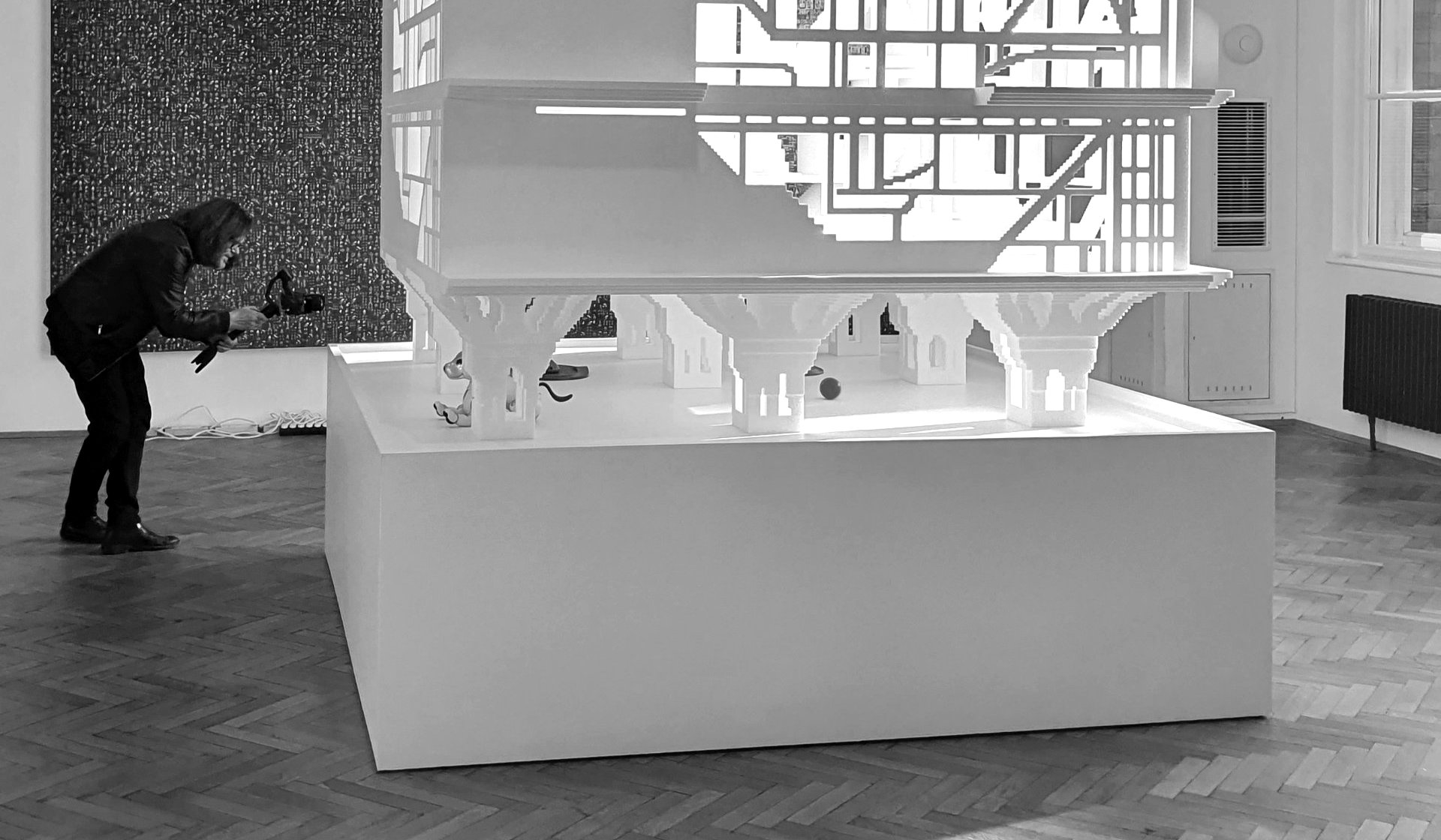 Doghouse installation at MAK Vienna — large white AI-generated architectural model with AIBO robots inside